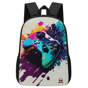 Può includere: Uno zaino nero con un pannello frontale bianco con un design a spruzzo di vernice colorato e un grande controller per videogiochi blu, verde e viola.