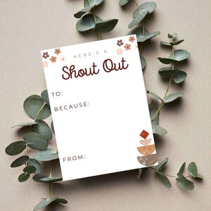 May include: A white card with brown text that says "Here's a Shout Out" with a floral border. The card has lines for "To:", "Because:", and "From:". There is a brown, orange, and red abstract design in the bottom right corner.
