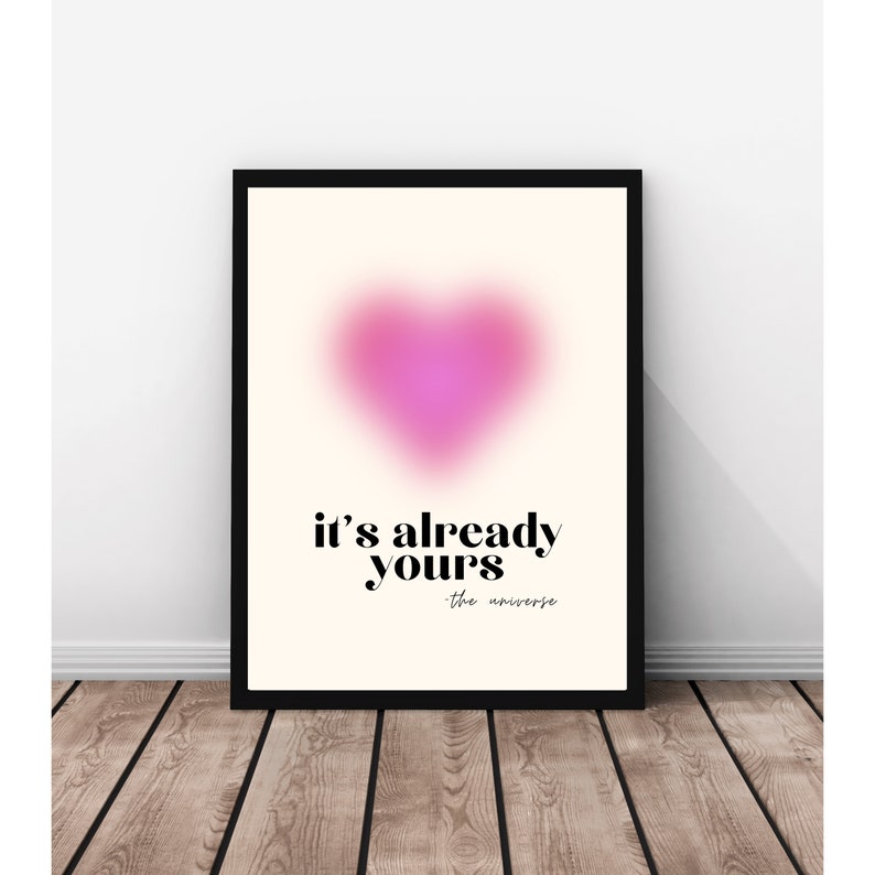 May include: A pink heart-shaped graphic with a blurred effect on a cream background. The text "it's already yours - the universe" is below the heart.