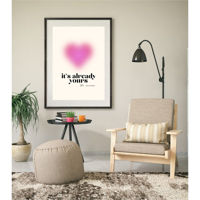 May include: A framed print with a pink heart and the text "it's already yours the universe" in black lettering.