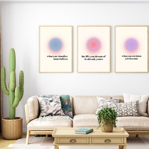 May include: Three framed prints with pastel coloured backgrounds and inspirational quotes. The quotes are "what you visualise materialises", "the life you dream of is already yours", and "what you envision you become".
