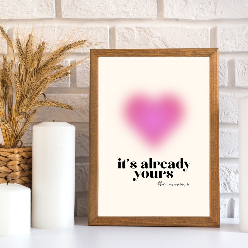 May include: A framed print with a pink heart shape and the text "it's already yours - the universe".