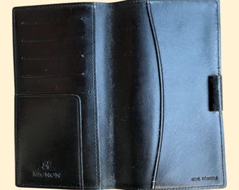 May include: Black leather wallet with multiple card slots and a large pocket. The wallet has the text "MIGNON" and "REAL LEATHER" embossed on the front.