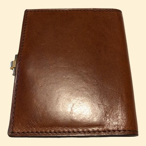 May include: A brown leather wallet with a gold clasp.