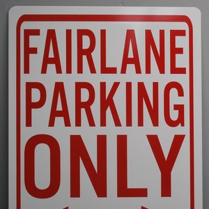 May include: Red and white sign with the text "FAIRLANE PARKING ONLY" and a double-headed arrow pointing left and right. The bottom of the sign reads "ALL OTHERS WILL BE TOWED."
