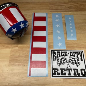 Può includere: Una tazza a righe rosse, bianche e blu con bordo cromato e una fascia blu con stelle bianche. Sono inclusi anche adesivi a righe rosse e bianche, adesivi blu con stelle bianche e un adesivo in bianco e nero "RACE CITY RETRO".