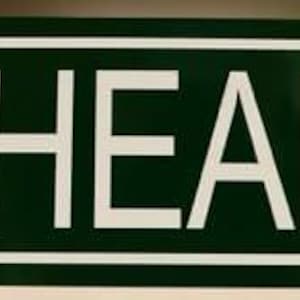 Puede incluir: Señal de tráfico rectangular verde con texto blanco "PANHEAD DRIVE". La señal tiene un borde blanco y probablemente está hecha de metal. Está diseñada para uso en exteriores, indicando el nombre de una calle.