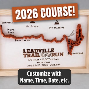 May include: A framed wooden map of the Leadville Trail 100 Run course with a raised orange path. Text includes 2026 COURSE!, Winfield, Mt. Elbert, Mt. Massive, Hope Pass, Twin Lakes, Turquoise Lake, Leadville, 100 miles - 13,357 ft gain, and Customize with Name, Time, Date, etc.