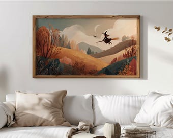 May include: A framed landscape art print featuring a witch flying on a broomstick over rolling hills. The artwork has a warm color palette of orange, brown, and green, with a crescent moon and a bird in the sky. The frame is made of wood.