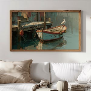 Puede incluir: Pintura enmarcada que representa una serena escena portuaria. Un pequeño bote azul claro con ribetes rojos está amarrado a un muelle de madera. Una gaviota blanca se posa en el bote. La obra de arte está en un marco de madera.
