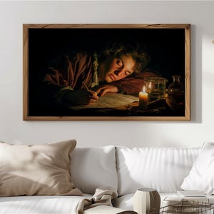 May include: A framed print of a classical painting depicting a person asleep at a desk, illuminated by candlelight. The person is wearing a red garment and writing on a piece of paper. A glass and a bottle are on the desk.