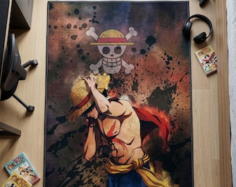 May include: A rectangular area rug featuring a graphic illustration of a shirtless anime character wearing a straw hat and a red cape, with a skull and crossbones emblem above. The background has a dark, splattered, fiery orange and black design.