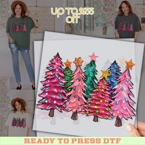 May include: A colorful DTF (Direct to Film) transfer featuring a row of stylized Christmas trees in shades of pink, green, and blue, each topped with a star. The text "READY TO PRESS DTF" is at the bottom.