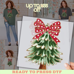 May include: A Christmas tree design with a red bow with white polka dots and gold trim. The tree is green with white accents and gold trim. The words "READY TO PRESS DTF" are at the bottom of the image.