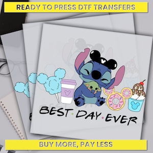 May include: Blue Stitch character wearing Mickey Mouse ears and holding a small green character. The image includes a cotton candy, a cup of coffee, two donuts, and a cup of ice cream with a cherry on top. The text "BEST DAY EVER" is below the characters.