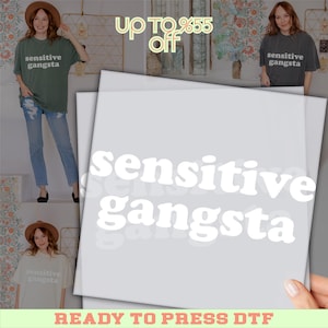 May include: A light gray graphic featuring the words "sensitive gangsta" in a bold, white font. The image also shows a green t-shirt and a gray t-shirt with the same text. The phrase "READY TO PRESS DTF" is at the bottom.