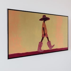 Könnte beinhalten: Gerahmter Kunstdruck, der eine Person zeigt, die mit Hut, gelbem Hemd, Shorts und rosa Cowboy-Stiefeln geht. Der Hintergrund ist ein Farbverlauf aus Gelb und Orange, mit einer dunkelroten Linie am unteren Rand.