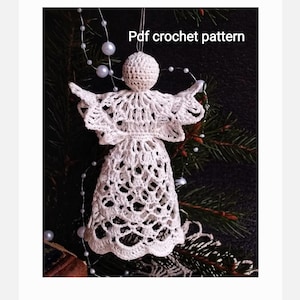 Puede incluir: Adorno de ángel de crochet blanco con un diseño de encaje. El ángel está colgado de una rama de árbol con una cadena de cuentas blancas en el fondo. El texto "Pdf crochet pattern" está escrito en la parte superior de la imagen.