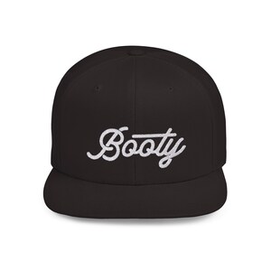 May include: A black, flat-brimmed baseball cap with the word "Booty" embroidered in white cursive script across the front. The hat has a structured crown and a flat brim.
