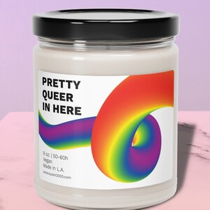 Peut inclure: Un pot de bougie blanc avec un couvercle noir et une étiquette arc-en-ciel. L'étiquette indique "Pretty Queer In Here" et présente un motif de tourbillon arc-en-ciel. La bougie est de 9 oz et a un temps de combustion de 50 à 60 heures. Elle est végétalienne et fabriquée à L.A.