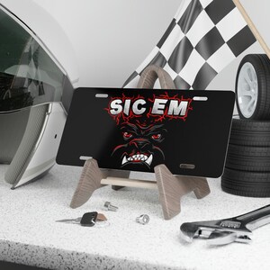 May include: Black metal license plate with a red and white bulldog graphic and the text "SIC EM".