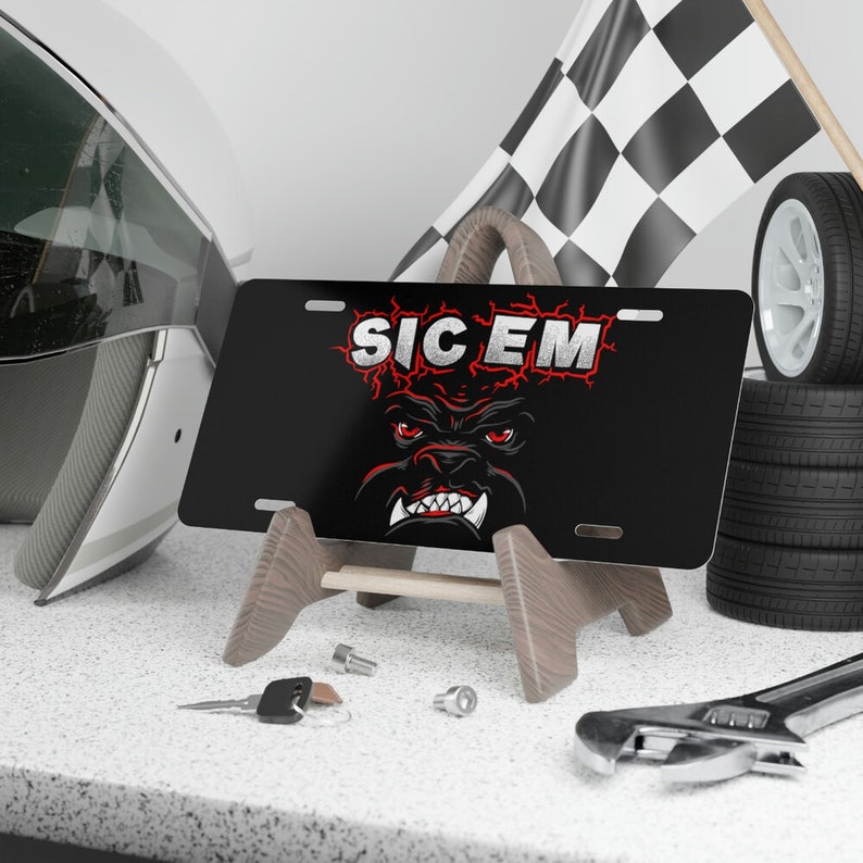 May include: Black metal license plate with a red and white bulldog graphic and the text "SIC EM".