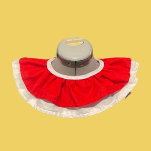 May include: A red and white ruffled collar with a white trim. The collar is made of fabric and is designed to be worn around the neck.