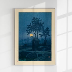 May include: A vintage Japanese woodblock print depicting a moonlit scene with a large pine tree and two small buildings in the foreground. The moon is a bright yellow circle in the sky, and the scene is bathed in a soft blue light.