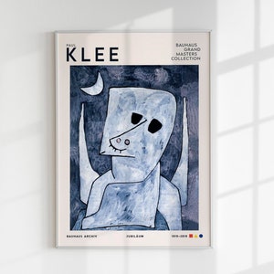 Può includere: Una stampa artistica incorniciata con un dipinto astratto blu e bianco di Paul Klee. L'opera raffigura una figura stilizzata con una luna crescente e il testo "PAUL KLEE". La stampa fa parte della Bauhaus Grand Masters Collection.