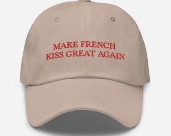 May include: A beige baseball cap with the text "Make French Kiss Great Again" embroidered in red.