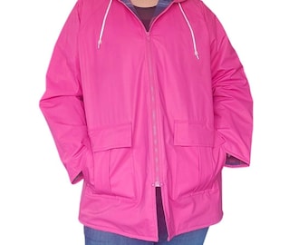 May include: A bright pink hooded rain jacket featuring a full-length front zipper, two large front patch pockets with flaps, and white drawstring cords. The interior lining displays a dark blue and red plaid pattern visible at the hood and cuffs.