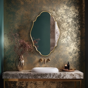 Renaissance Mirror with gold frame hung on the wall of a powder room over a vanity.
