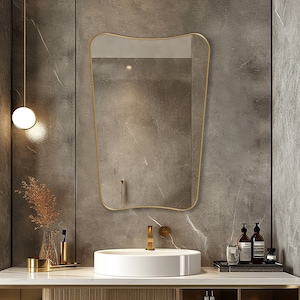 Italian mirror with gold frame hung on the wall of a bathroom.