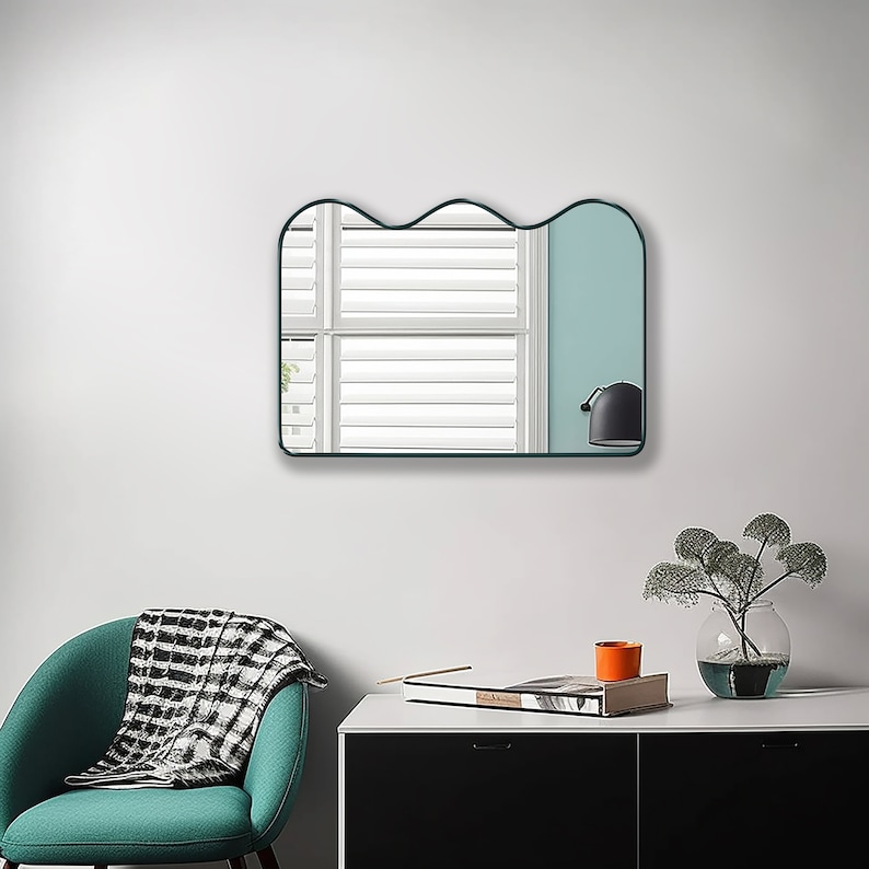 Squiggle mirror with emerald frame hung on the wall of an office.