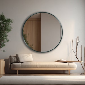 Round mirror with emerald frame hung on the wall of an entryway.