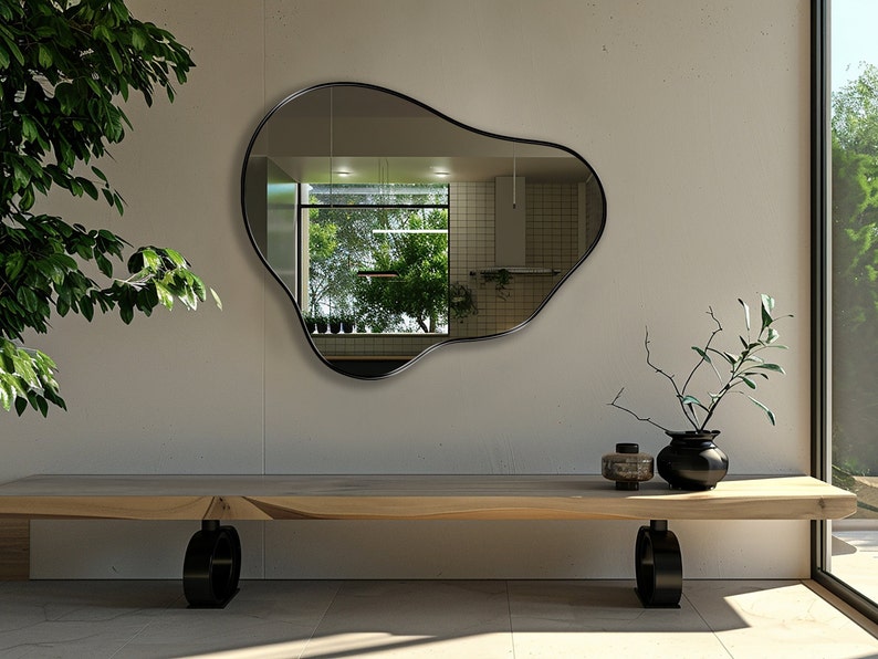 Organic Pebble Mirror with black frame finish hung on the wall of an entryway, over a bench.