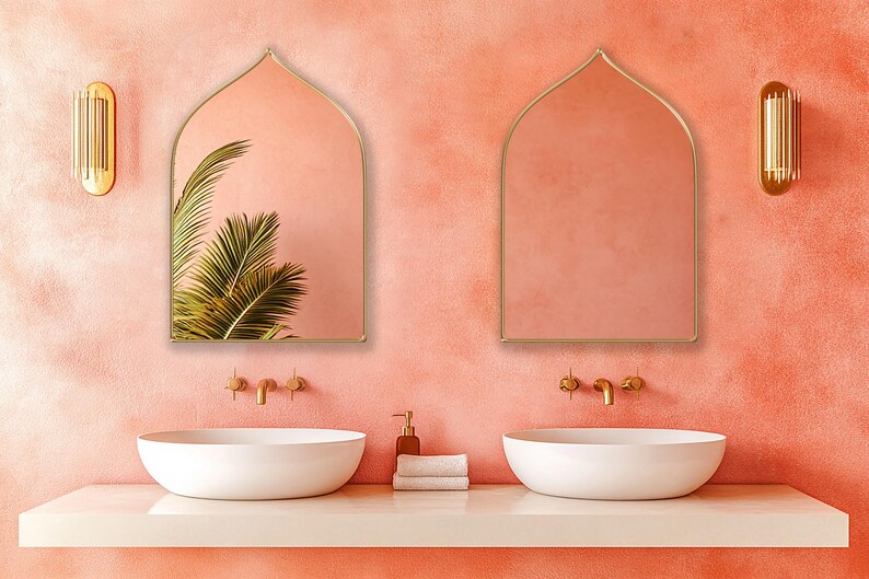 Two Sahara Mirrors with gold frame finish hung on the wall of a bohemian bathroom over a double vanity.
