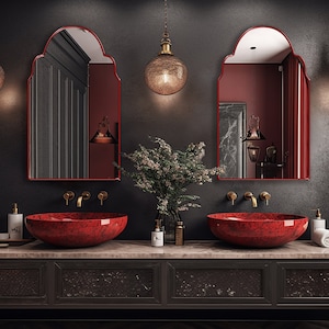 Two Arched Moroccan Mirrors with red frame finish hung on the wall of a bathroom over a double vanity.