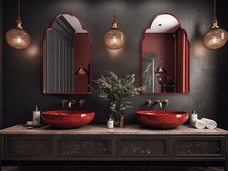 Two Arched Moroccan Mirrors with red frame finish hung on the wall of a bathroom over a double vanity.