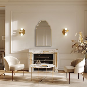 Arched Moroccan Mirror with gold frame finish hung on the wall of a living room over a fireplace.