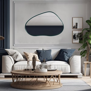 Pond mirror with emerald frame hung on the wall of a living room.