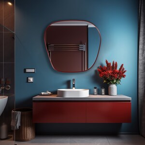 Blob mirror with red frame finish hung on the wall of a bathroom over a vanity.