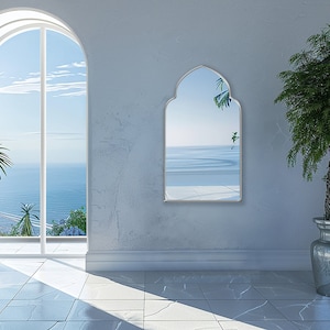 Accent Mirror with silver frame finish hung on the wall of an entryway.