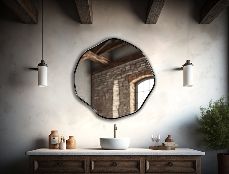 Circular Asymmetrical Mirror with Black Frame hung on the wall of a hallway.