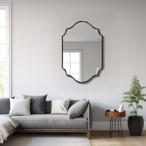 Quatrefoil mirror with black frame hung over the wall of a living room.