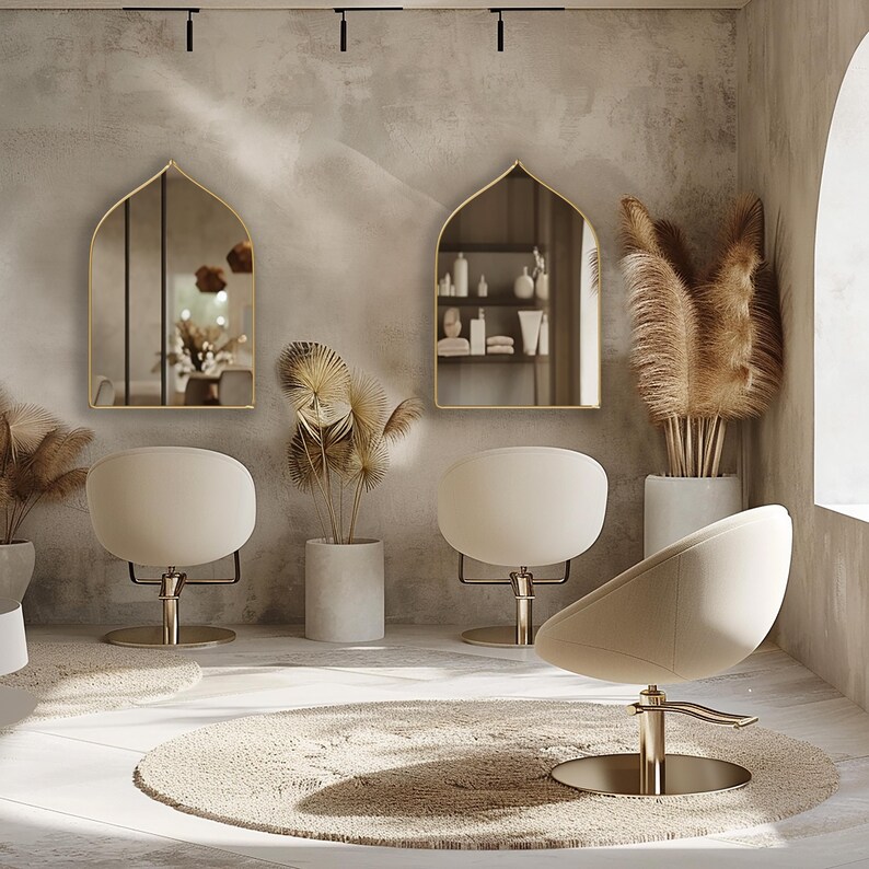 Two Sahara Mirrors with gold frame finish hung on the wall of an hairdresser.