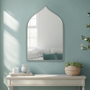 Sahara Mirror with silver frame finish hung on the wall of an entryway over a console.