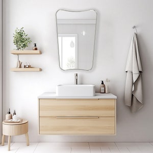 Italian Mirror with silver frame hung on the wall of a bathroom above a vanity.
