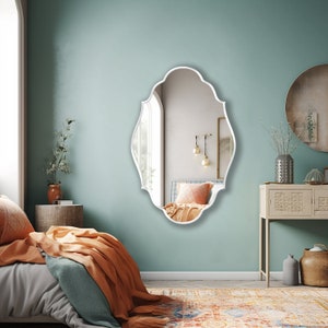 Renaissance Mirror with white frame hung on the wall of a luxury living room.