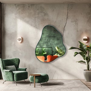 Organic Pebble Mirror with emerald frame finish hung on the wall of a living room, over an armchair.